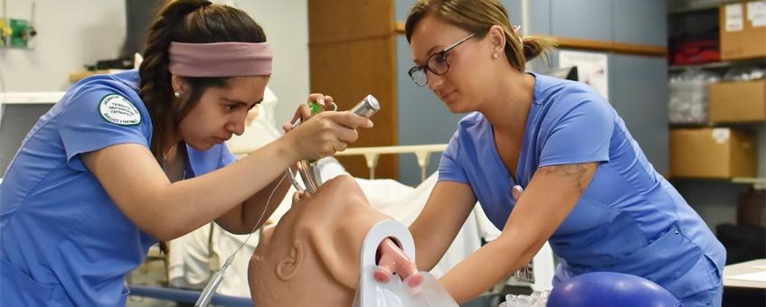 Two Respiratory Care students working with a test dummy.